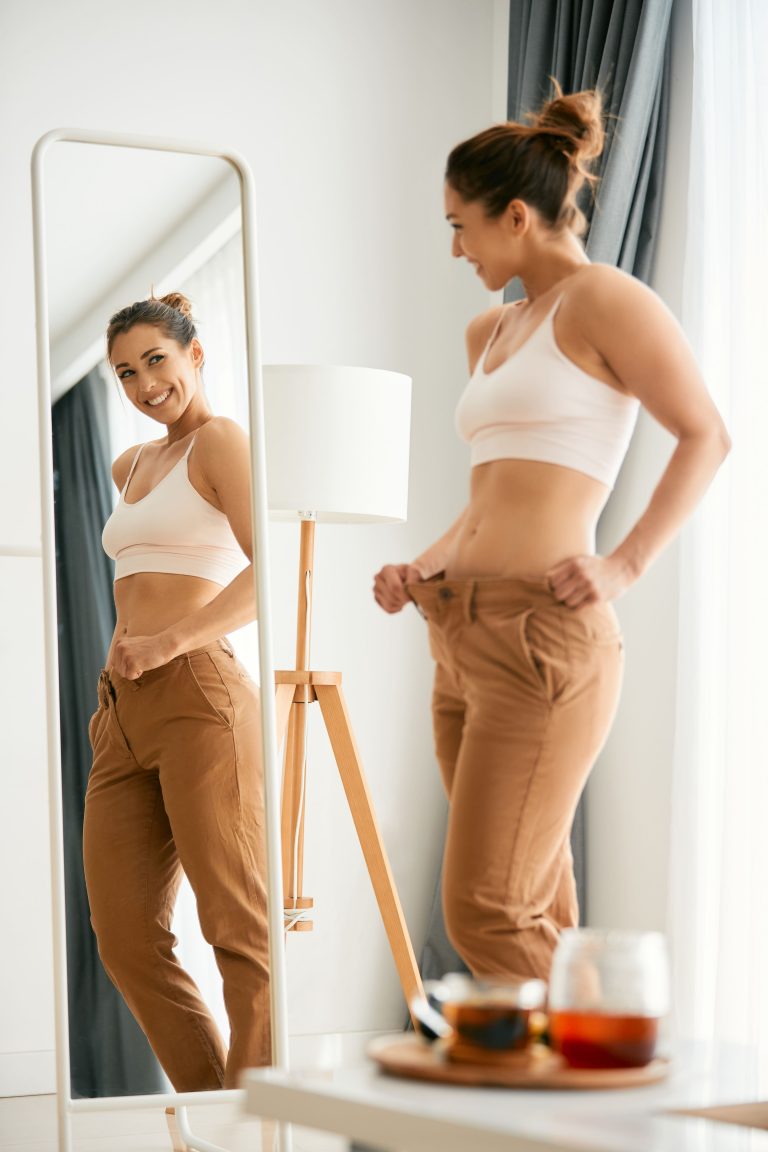 Frau vor einem Spiegel-Liposuktion am Gesäß