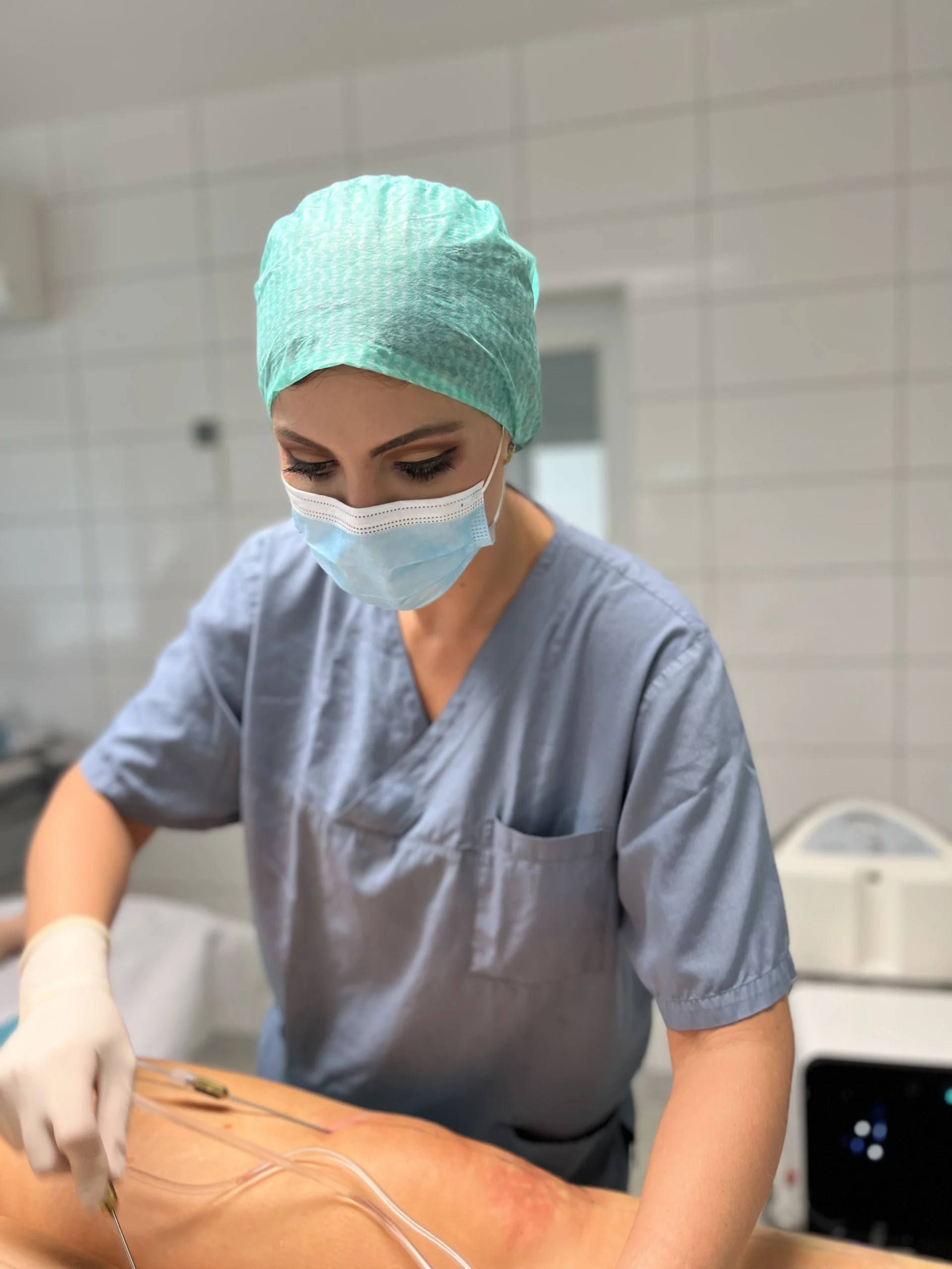 Medizinischer Profi in OP-Kleidung konzentriert sich auf den Eingriff mit Instrumenten in klinischer Umgebung.